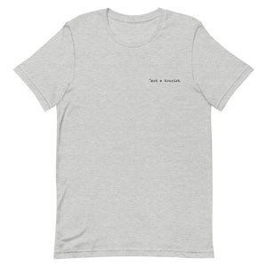 *not a tourist Short-Sleeve Unisex T-Shirt (left)